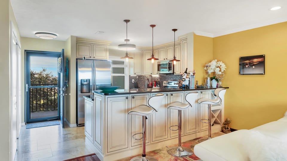 Fully equipped gourmet kitchen with bar seating and modern appliances.