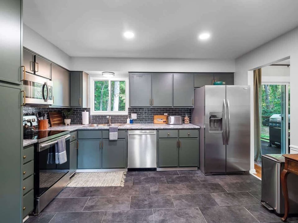 Modern kitchen w/ dark cabinetry, stainless appliances & clean lines
