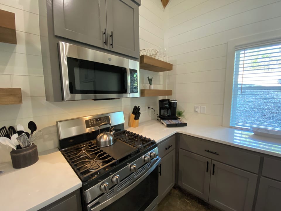 Cook in a cozy kitchen with wood accents and sleek stainless appliances. 