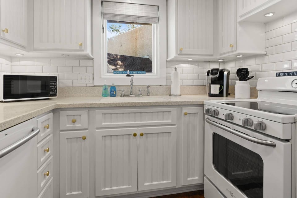 Kitchen includes a beautiful white subway tile backsplash with a window to let natural light flow in.