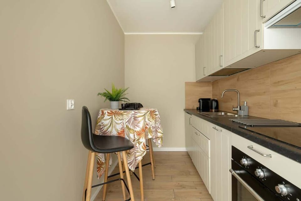 Modern kitchen with dishwasher and oven. The kitchen has a table creating a comfortable space for dining. 