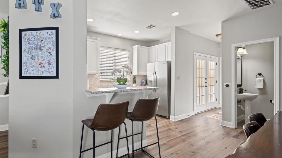 Newly renovated kitchen area with bar stools and counter area