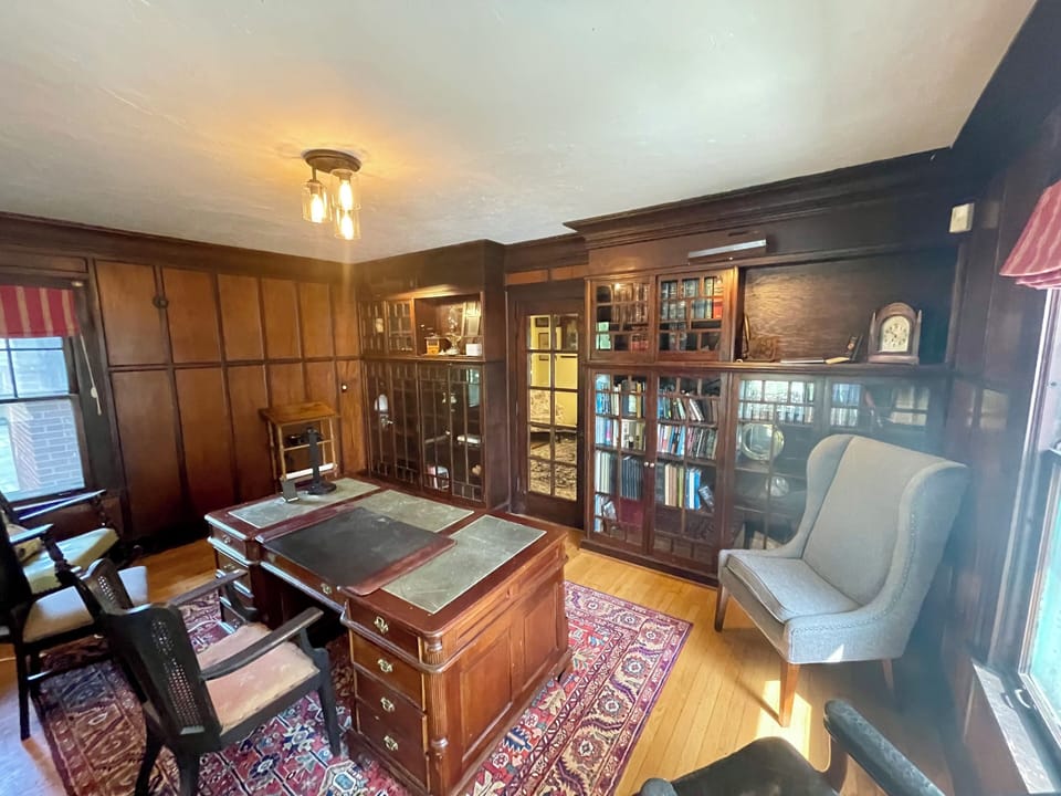 The walnut paneled library can serve as a private office or workspace.