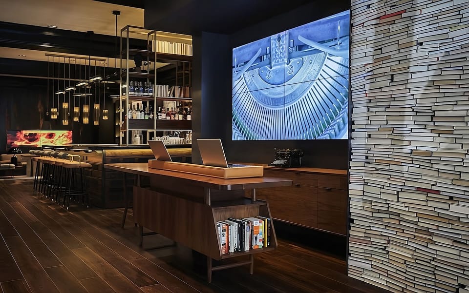 Sip craft cocktails beside warm shelves and moody lighting.