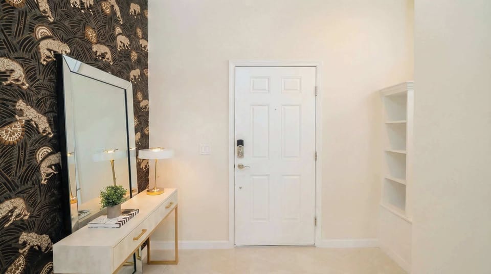 Stylish entryway with bold wallpaper, elegant console, and welcoming vibe.