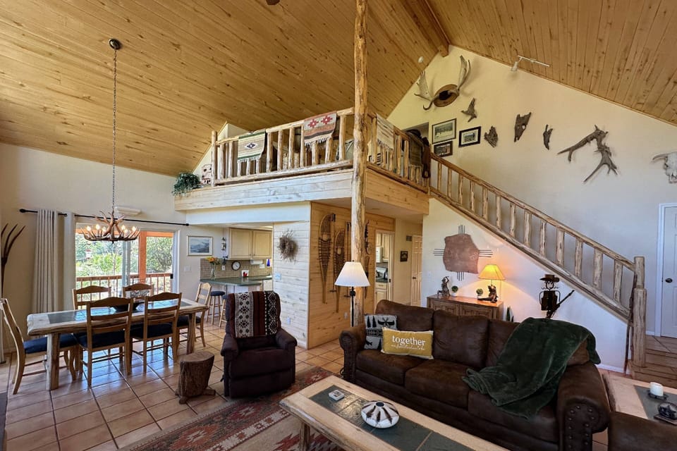 View from the corner of the living room is your view of the upper level, main living, dining and open lofted space.