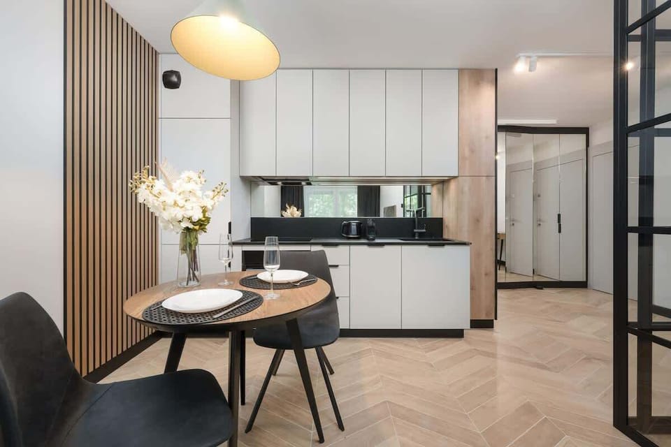 A sleek dining and kitchen area with modern furniture and soft lighting. Ideal for hosting intimate dinners.