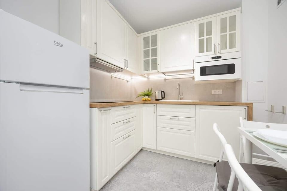 Kitchen includes all necessary kitchen accessories and appliances, such as an induction cooktop, refrigerator with freezer, and microwave, making everyday cooking easy.