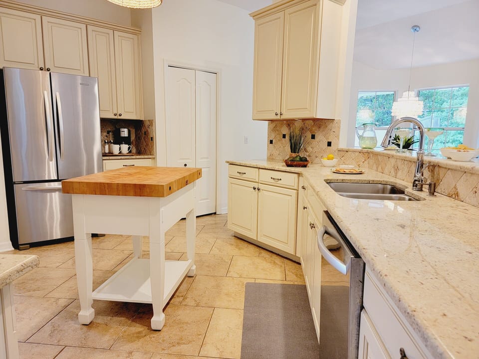 Kitchen boasts a unique butcher block island and stainless steel appliances