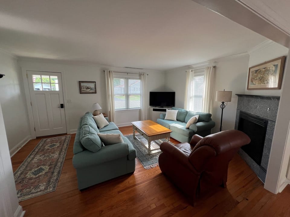 Living room with smart TV, fireplace and queen sofa bed.