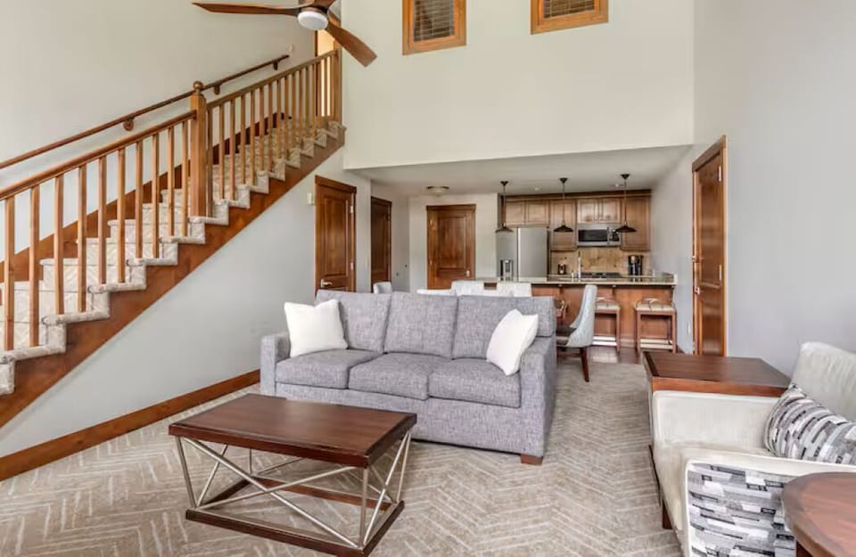 one version of kitchen,  sleeper sofa and stairs leading to loft and bedrooms