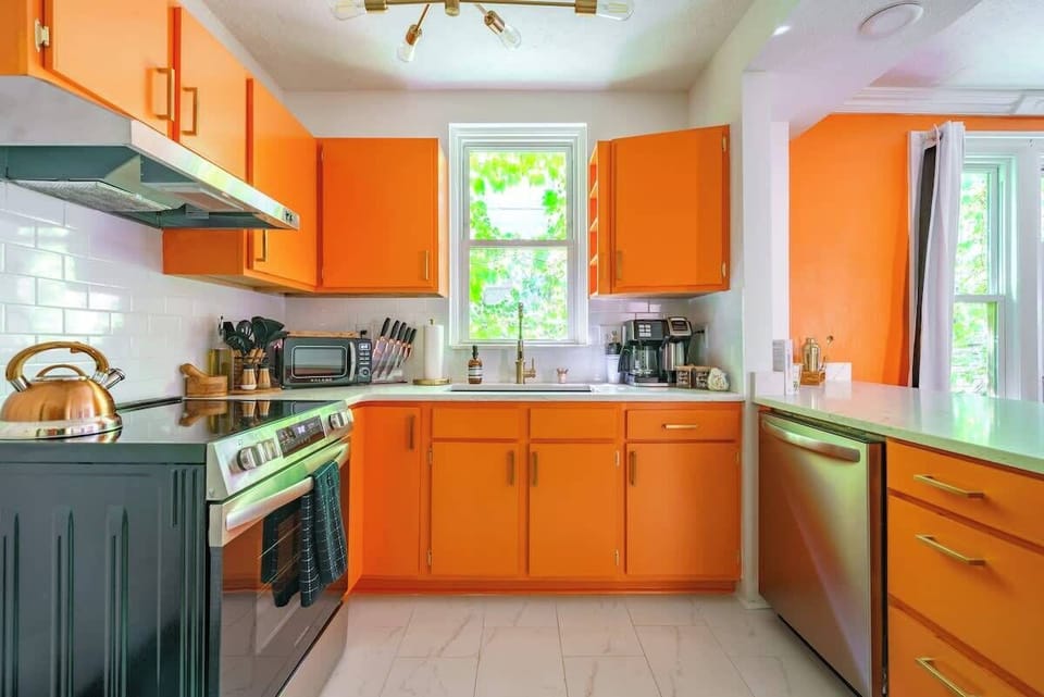 This kitchen shines with its energizing orange cabinetry, making a lively statement that’s impossible to ignore.