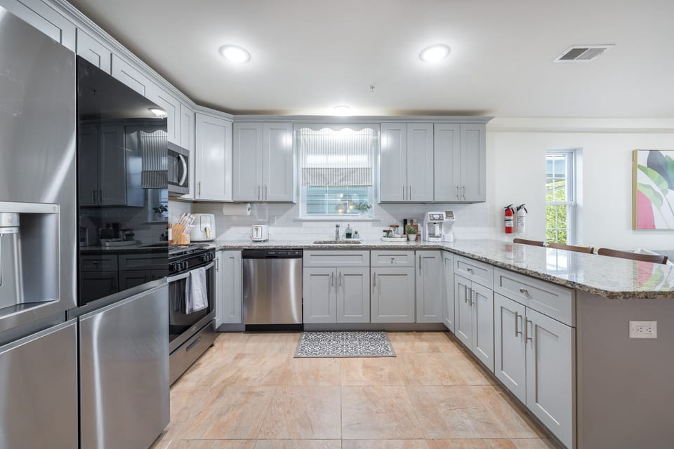 Step into a brand new kitchen featuring sleek stainless steel appliances, including a refrigerator, oven, microwave, and dishwasher. The modern design and high-quality appliances ensure a top-notch cooking experience