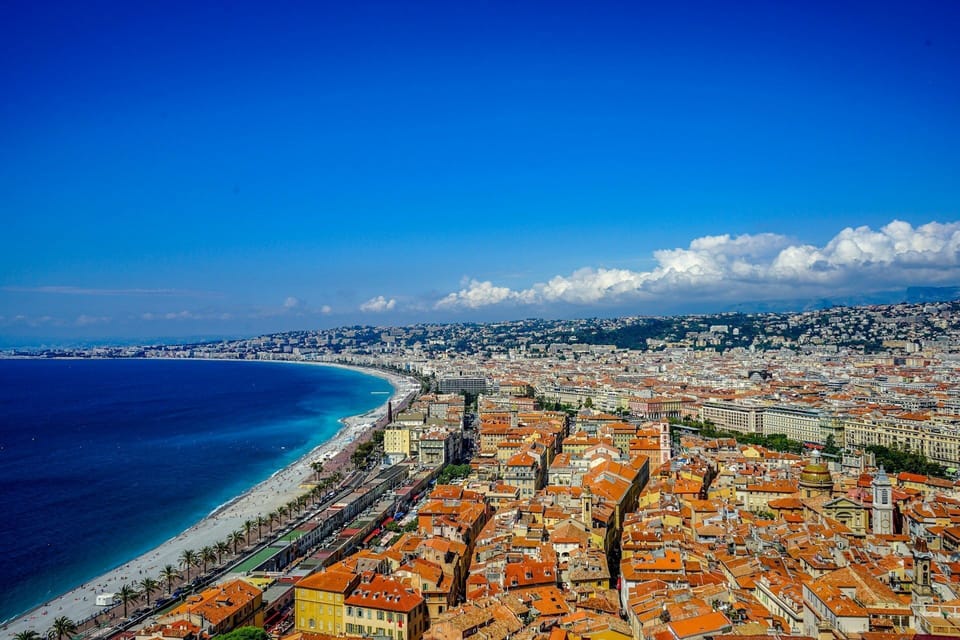 Nice's sun-drenched cityscape of terracotta rooftops and the sweeping arc of the Baie des Anges, seen from the heights of Castle Hill.