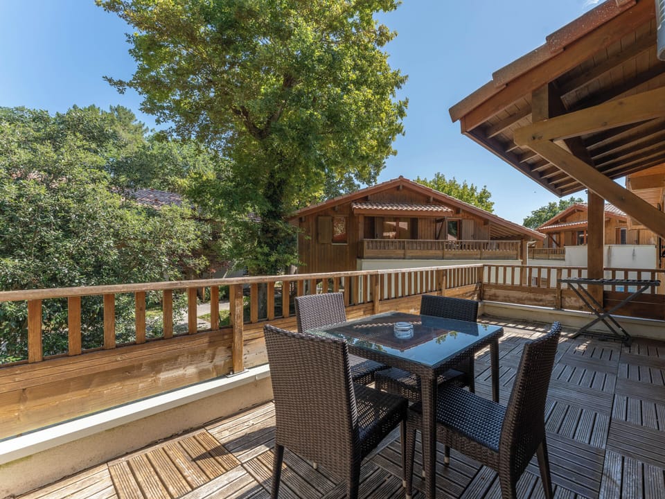 A spacious elevated terrace shaded by the pine canopy — the ideal setting for an alfresco dinner after a day at Moutchic Beach, just 450 metres away.