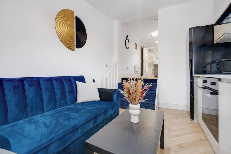 A bright double bedroom that opens onto the living area with a few steps down, featuring a wall-mounted Smart TV, clothes hanger, and private ensuite.