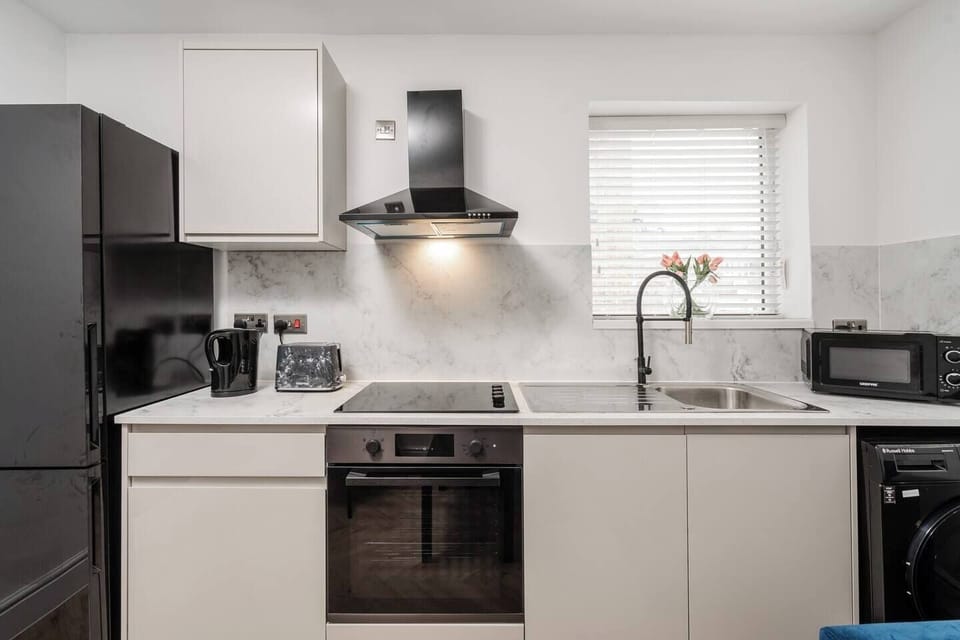 A compact, fully equipped kitchen with an induction hob, oven, microwave, fridge, toaster, and all the essentials you need to prepare simple meals during your stay — practical, convenient. No tea, coffee, or sugar is provided at this stage.