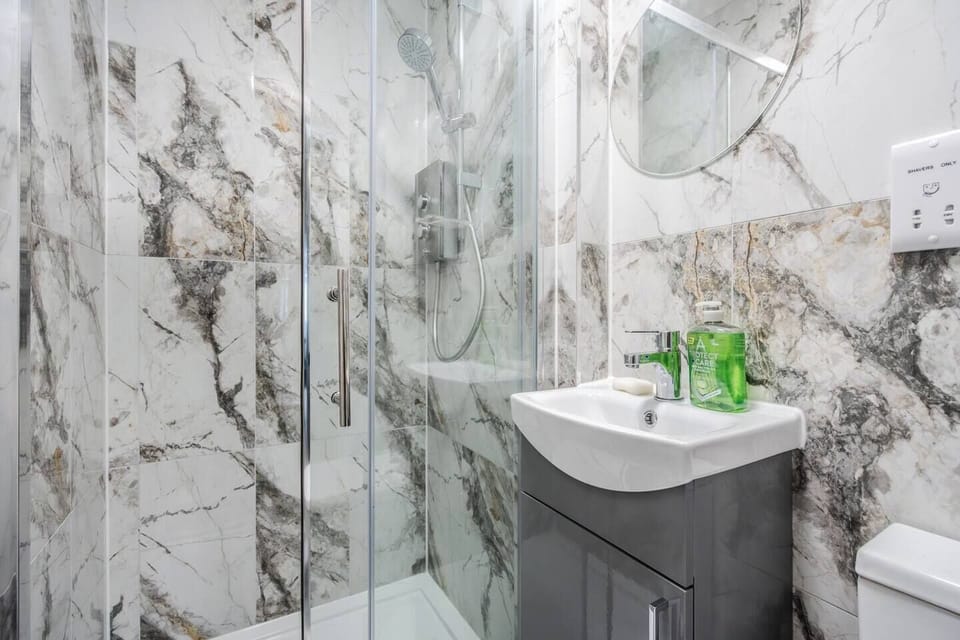 A clean and functional private bathroom with shower, toilet, and sink. Towels, hand soap, and toilet rolls are provided for your stay. Please note: body wash, shampoo, and other hair products are not supplied.