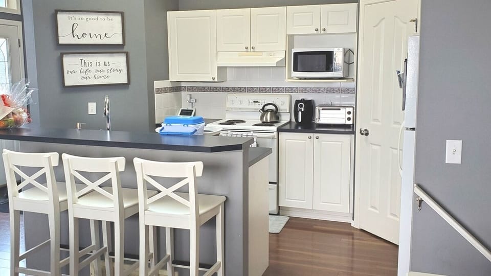 Spacious kitchen with bar stools for quick bites to eat on the go! 