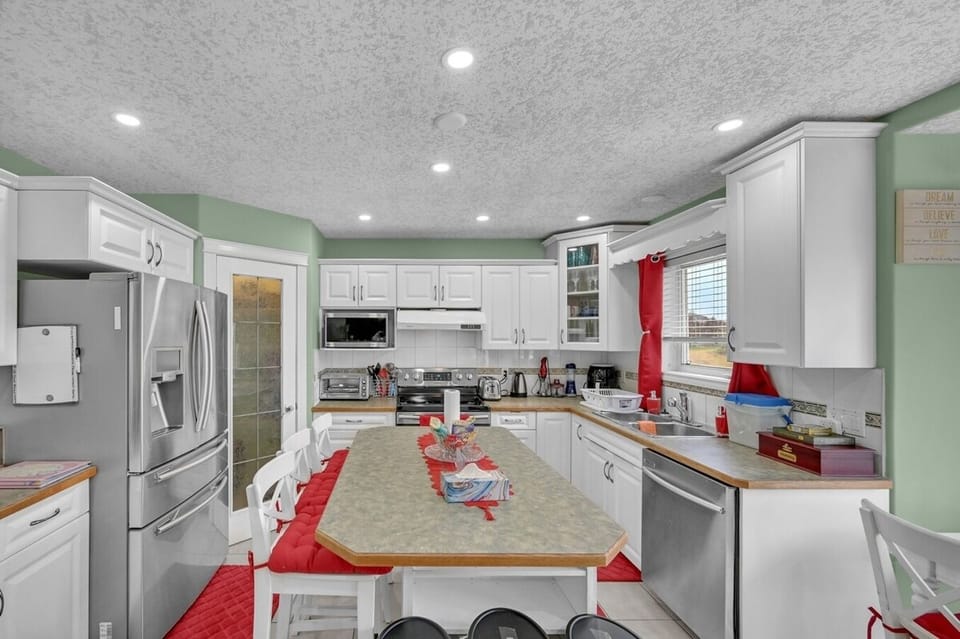 Spacious kitchen with new stainless steel appliances and additional seating at the kitchen table and island with bar stools! 