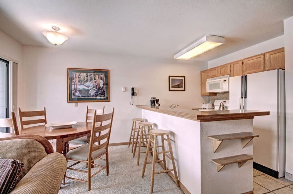 Cook and dine in the open kitchen and dining area with a breakfast bar, ample counter space, and comfortable seating for meals.