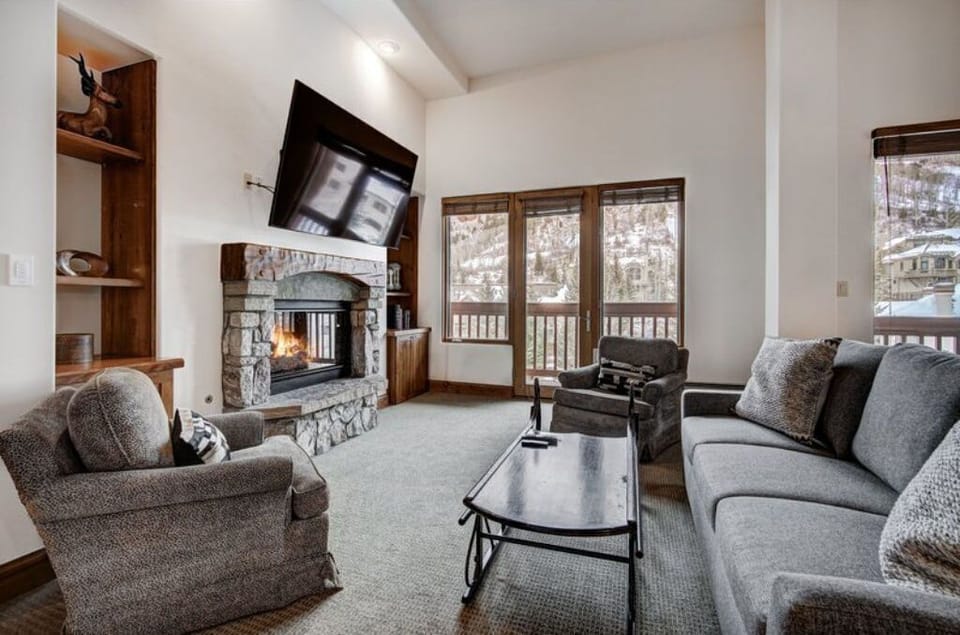 Relax in the cozy living room, equipped with a warm fireplace, comfortable seating, and a large flat-screen TV for your entertainment.