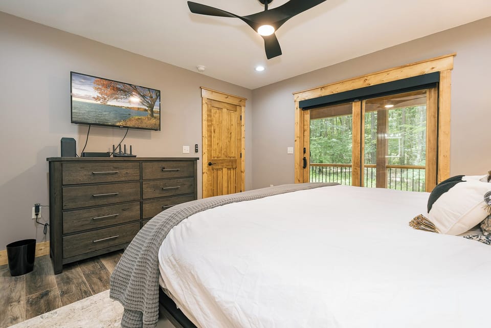 Main level primary suite furnished with a TV.