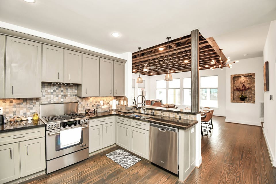 Kitchen fully equipped with dishwasher, oven, double large sink, and stove top. 