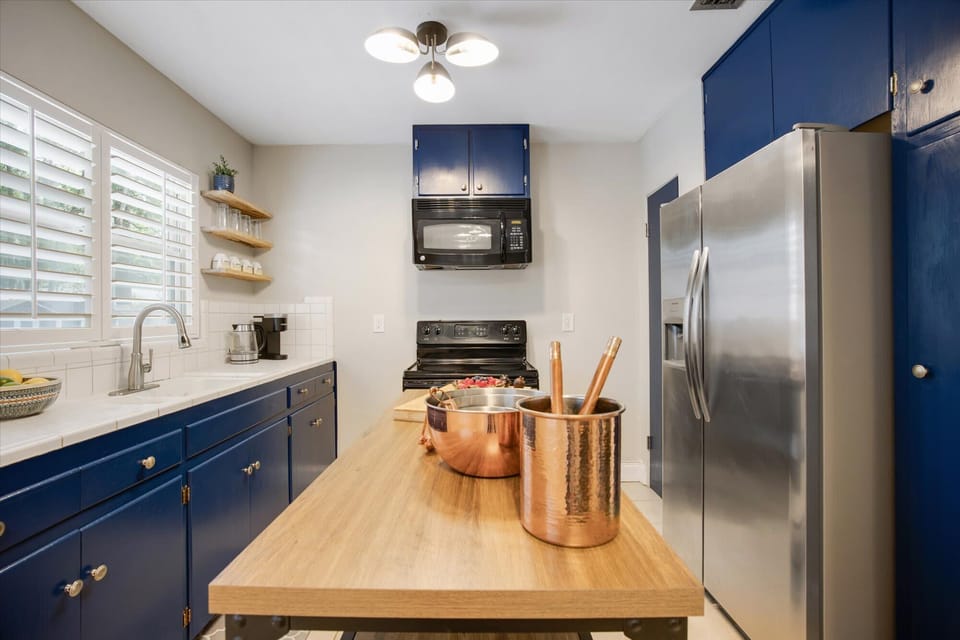 "Gourmet Kitchen with Bold Modern Style"
Cook in style with our striking navy cabinetry, sleek stainless steel appliances, and a spacious wooden island perfect for meal prep.