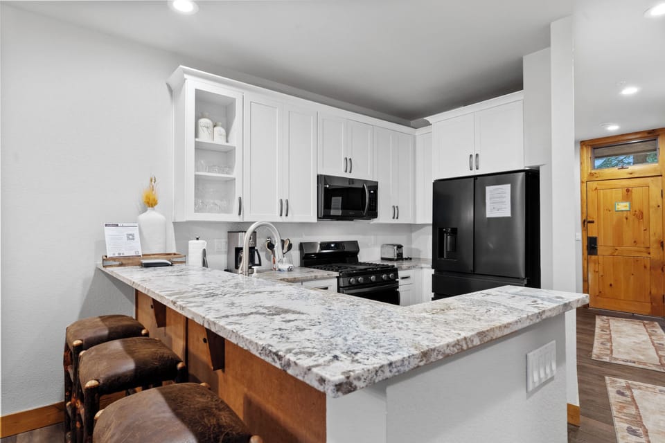 Your modern kitchen features granite countertops, white cabinets, and full appliances - perfect for preparing meals during your mountain getaway.