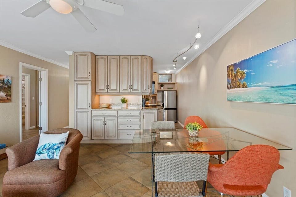 Gather around your glass dining table in this bright open-plan space, where coastal art and soft seating invite relaxed meals and good company.