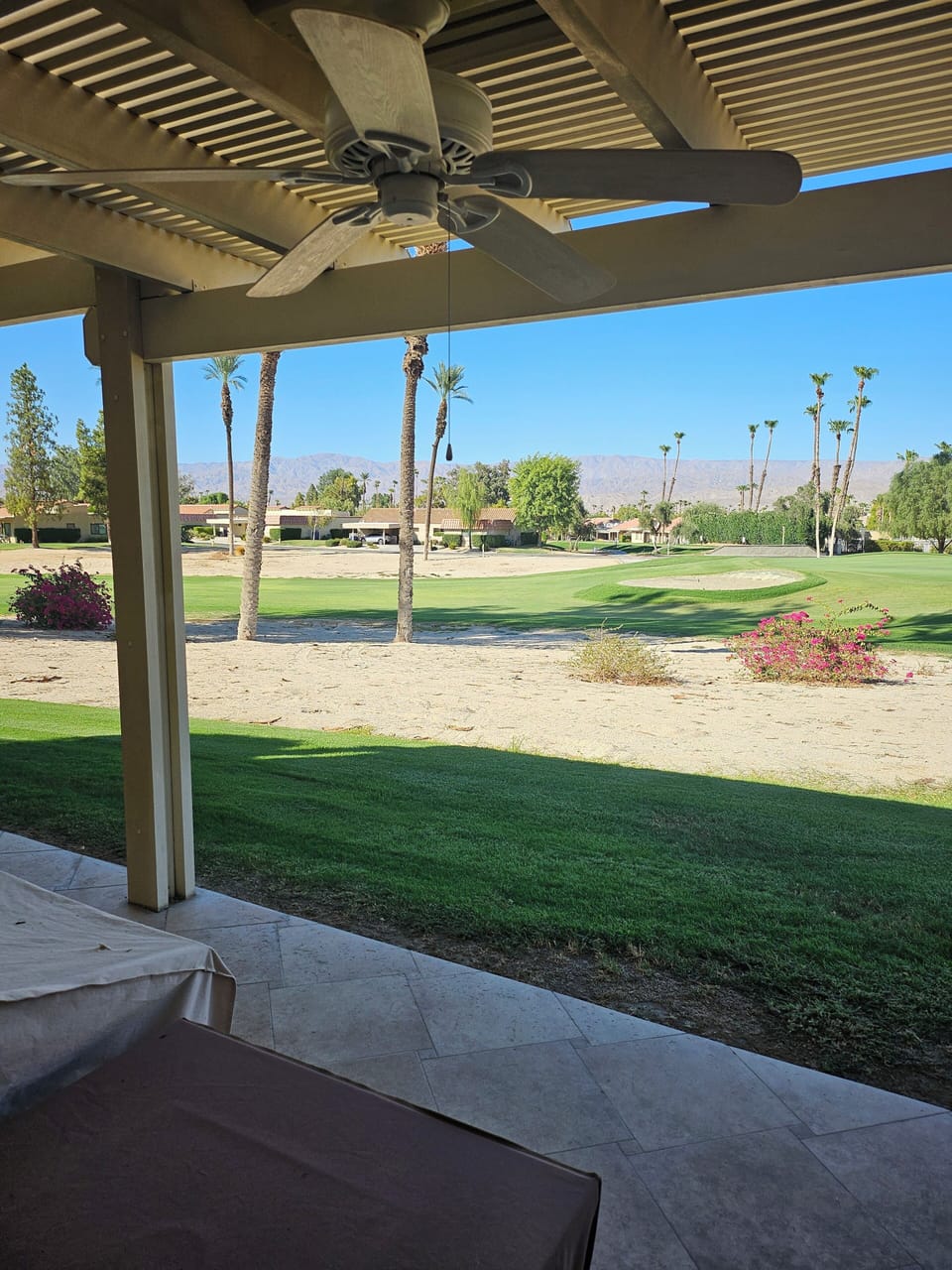 View from back patio , 2 outdoor fans, nice seating areas and gas grill.