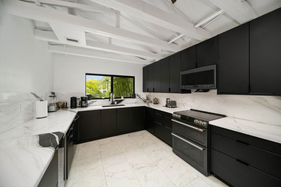Experience luxurious cooking with sleek black cabinets and marble countertops.