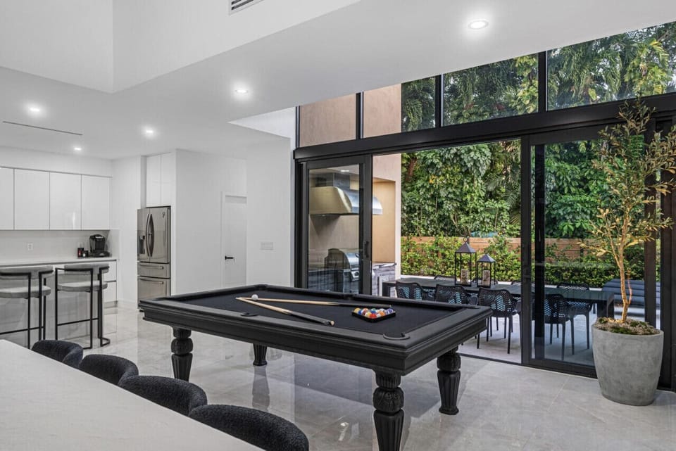 The game area, kitchen, and dining seamlessly connect to the outdoors.