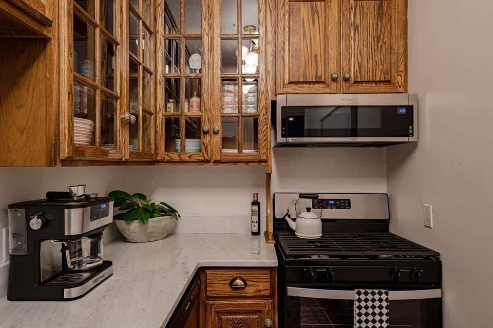 Classic kitchen corner w/ wood cabinetry, stove & coffee station ready for morning brews