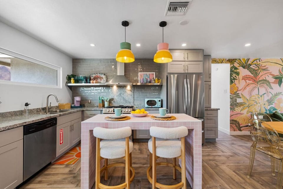 Cheerful bedroom featuring bold wall art, natural light & a cozy, laid-back feel.