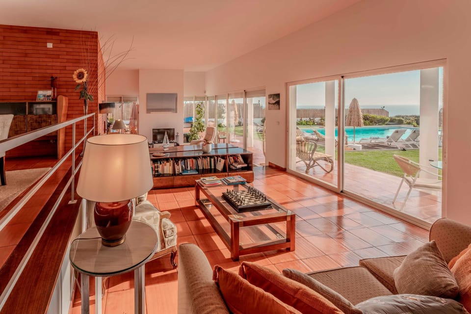 Bright open-plan living room with terracotta tiles and panoramic glass doors — Villa Atlantic Blue, holiday villa in Mafra