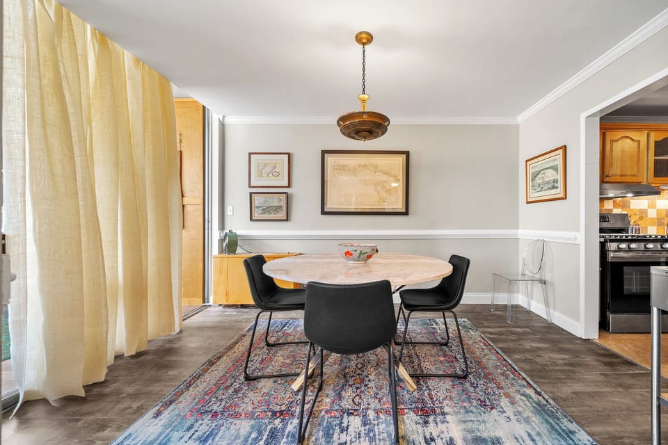 Stylish dining room w/ curated artwork, neutral tones & warm lighting