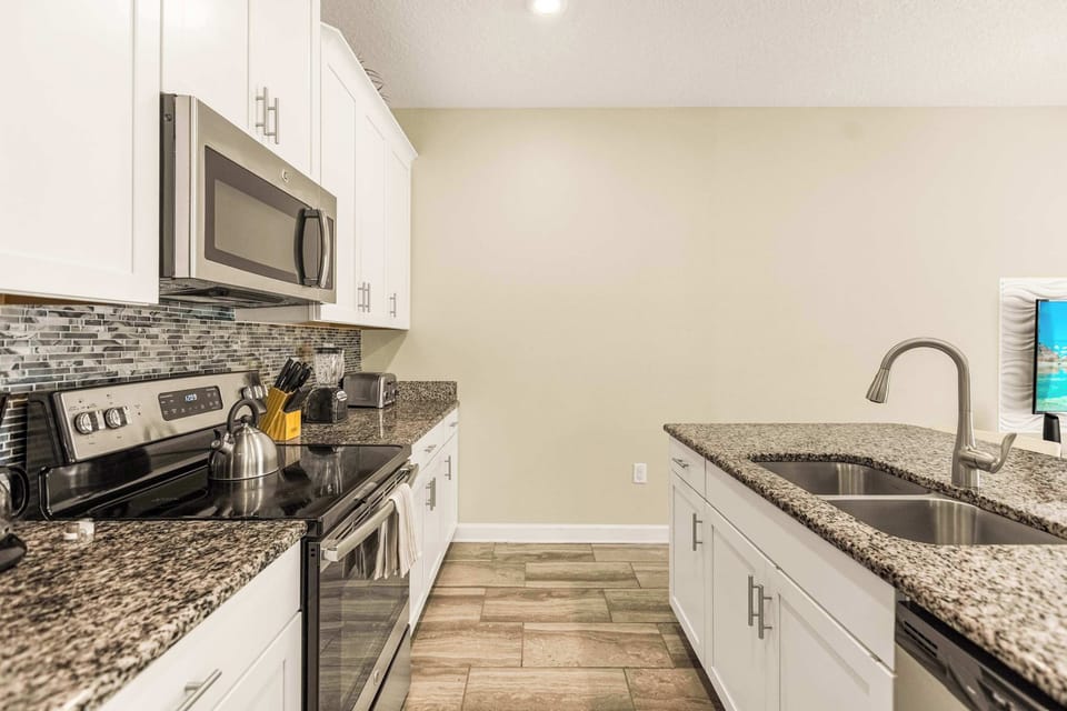 Sleek and modern kitchen with granite countertops and stainless steel appliances, perfect for culinary enthusiasts.