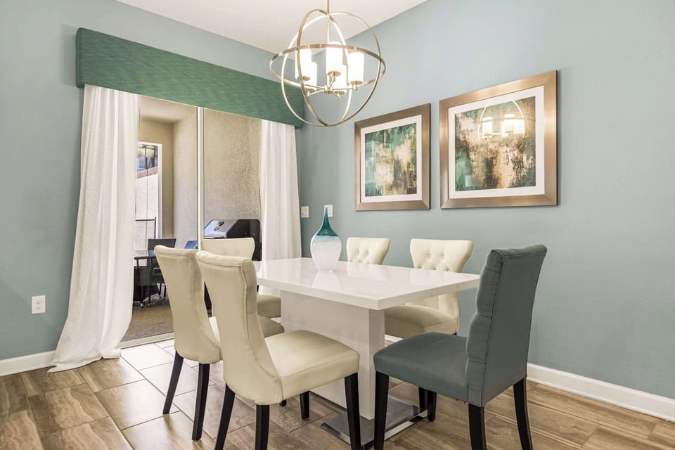 Elegant dining space with modern decor and access to a private patio with a grill, perfect for family gatherings.