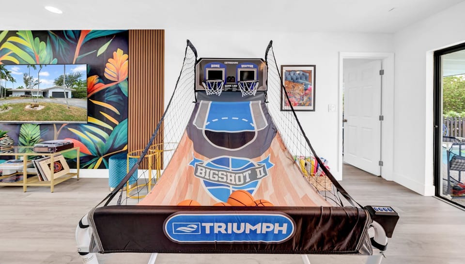 Modern entertainment room with basketball arcade game and tropical decor. Perfect blend of gaming and stylish living #ArcadeRoom #BasketballGame #TropicalDecor #EntertainmentRoom #GamingRoom #ModernLiving #TropicalTheme #ArcadeEntertainment
