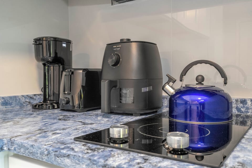 Full kitchen with refrigerator, freezer, stove, microwave, toaster, coffee maker