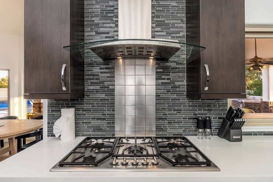 Your chef-inspired kitchen features a sleek gas stove and modern range hood, perfect for creating memorable meals during your stay.