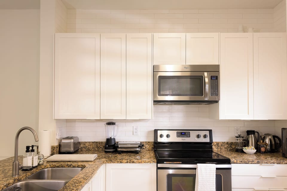Fully equipped kitchen: Refrigerator, dishwasher, blender, pots, pans, utensils.