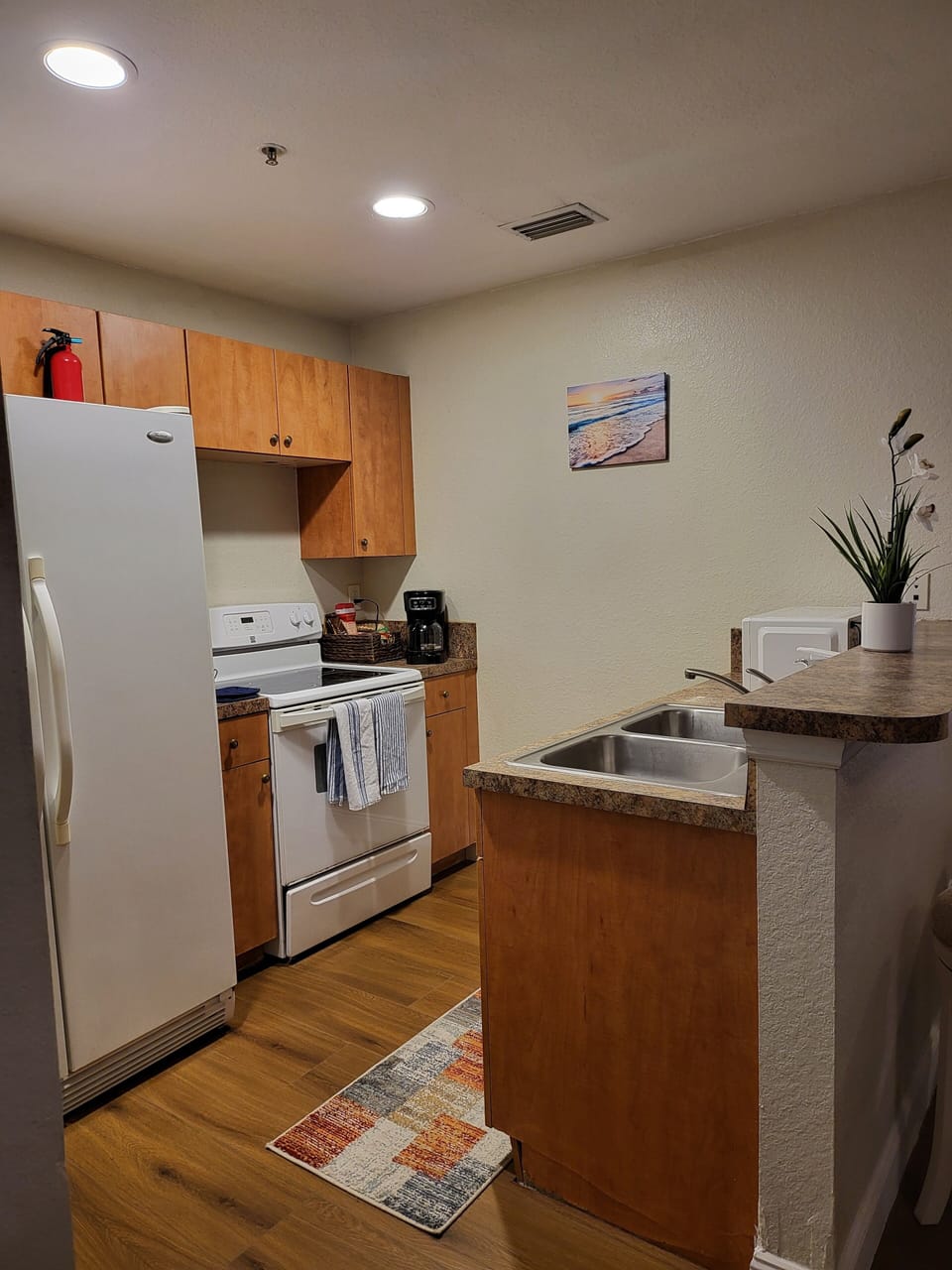 Kitchen with stove, microwave, blinder and coffee maker. 