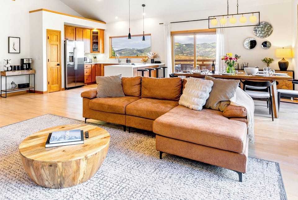 Vaulted ceilings, hardwood floors, and a wall of windows with breathtaking views