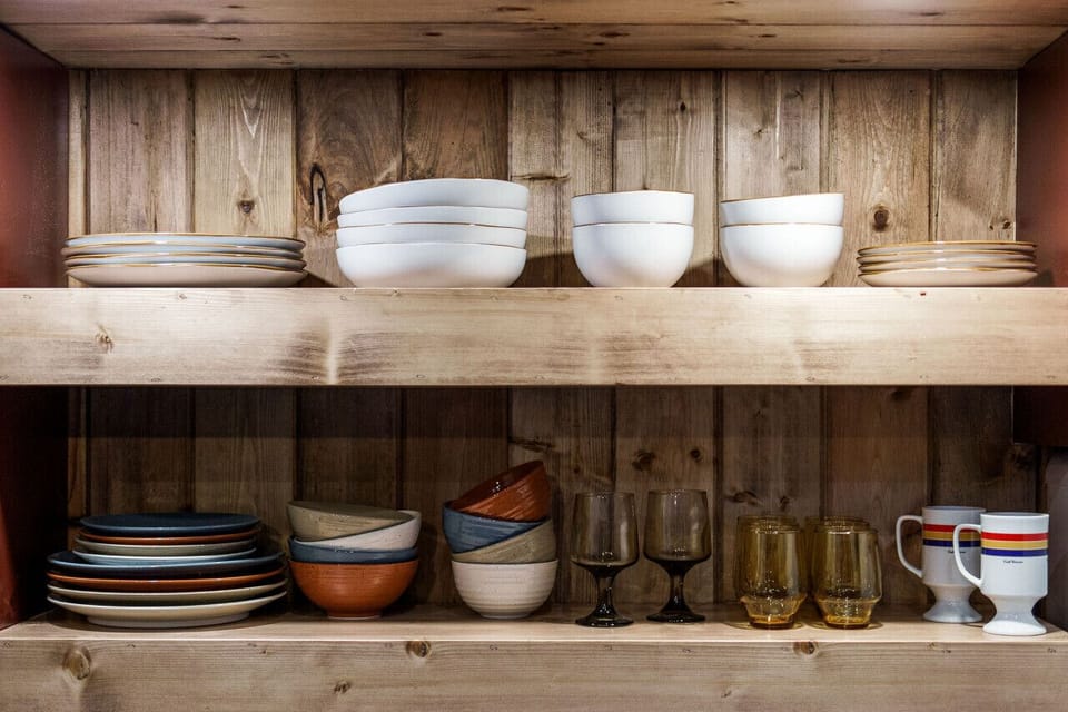 The kitchen features a two-burner electric cooktop, ice maker, microwave, toaster, blender, dishwasher, and refrigerator, along with a coffee maker that uses our custom Hideout coffee blend.