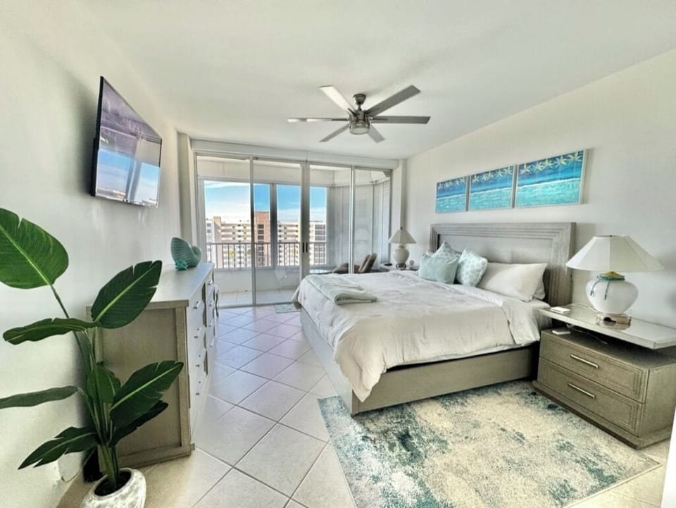 Master bedroom with king bed, walk-in closet and balcony access with a view.