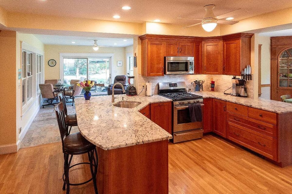 Full kitchen with modern appliances and loads of cabinets overlooks the sunroom.