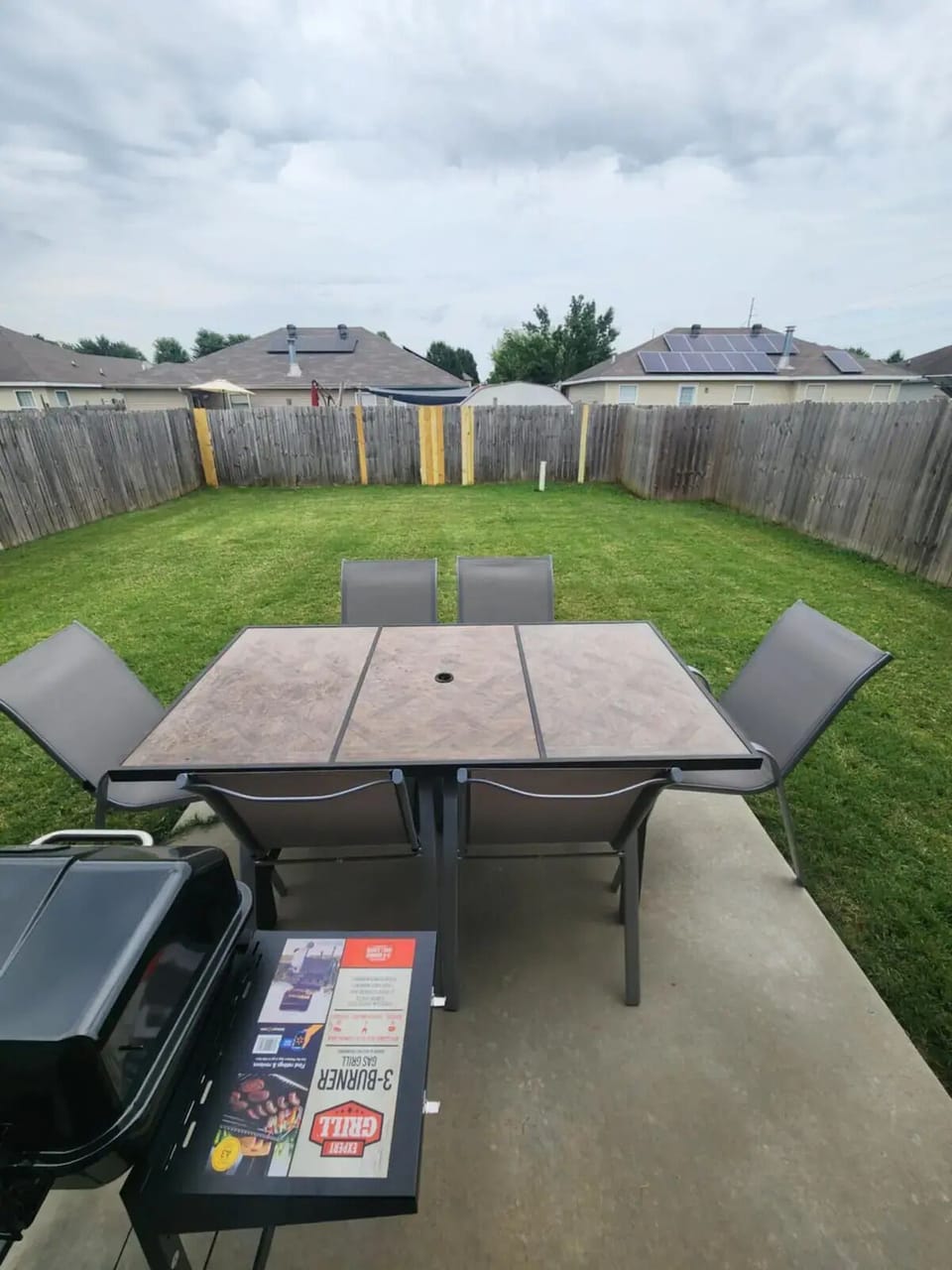 Fenced in back yard with grill